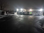 Commercial snow plowing a large business parking lot.