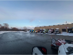 Snow removal crew clearing ice from a retail property walkway.